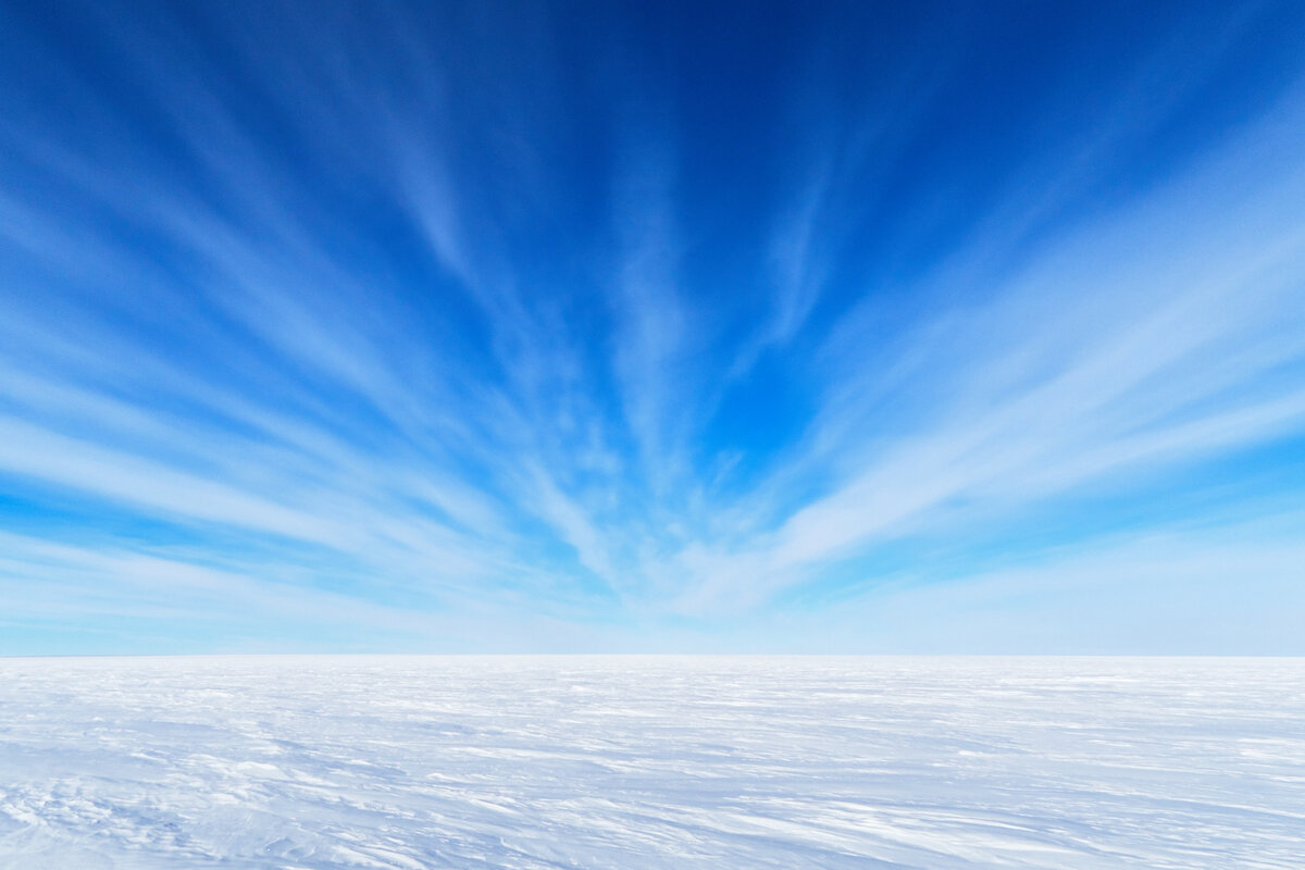 Endless white polar plateau against blue skies