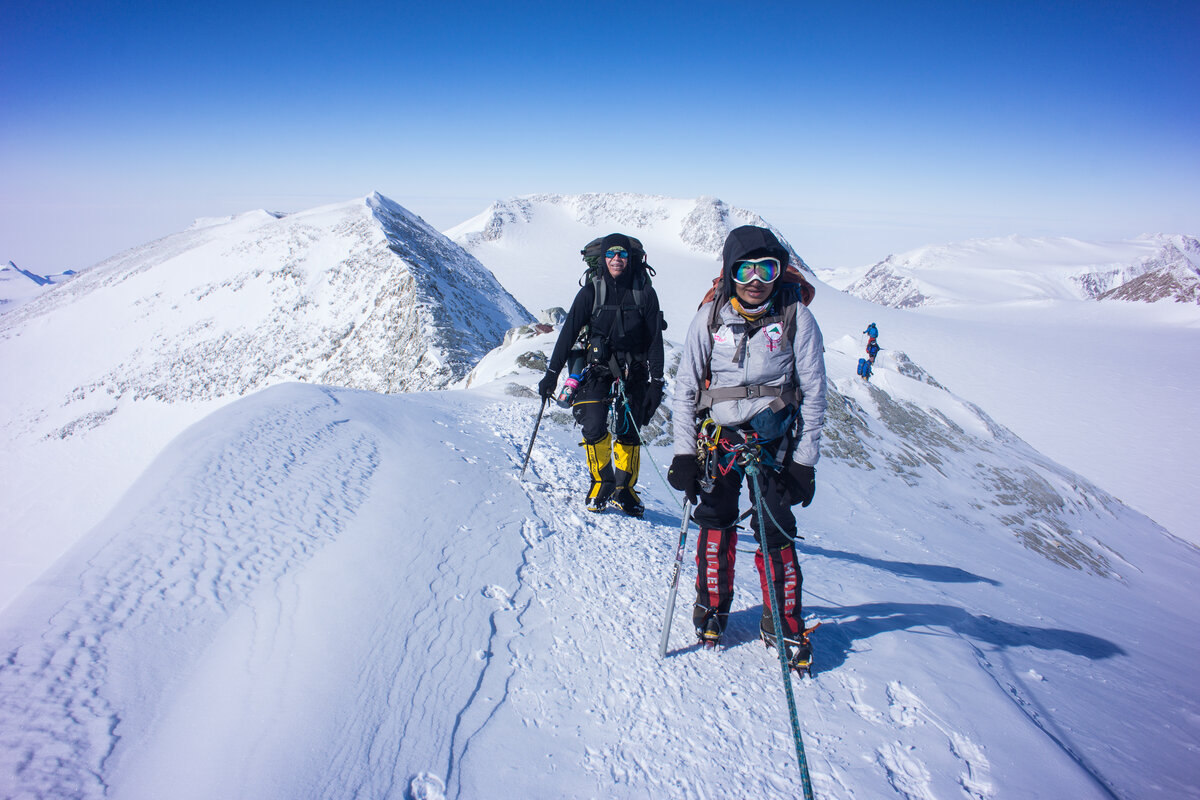 Two ALE guests walk along on the summit ridge